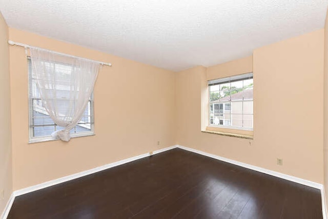 empty room with hardwood / wood-style floors and a textured ceiling