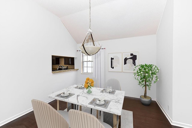 dining area featuring a textured ceiling, lofted ceiling, and dark wood-type flooring