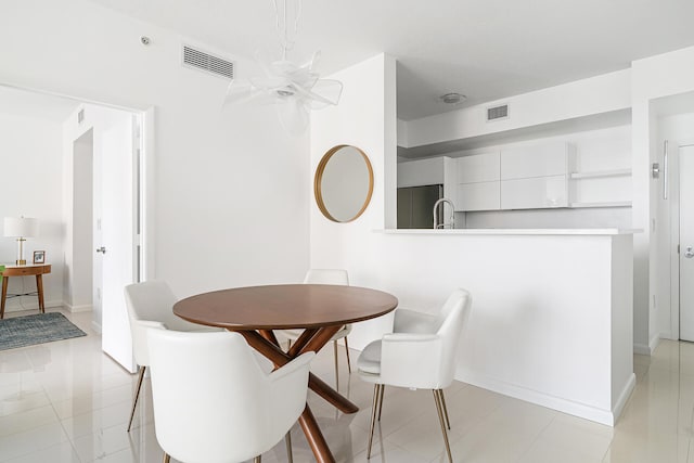 tiled dining room with an inviting chandelier and sink