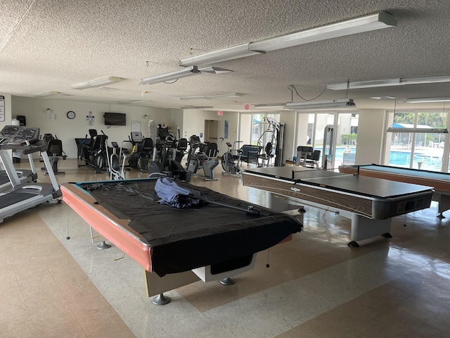 workout area featuring ceiling fan, billiards, and a textured ceiling