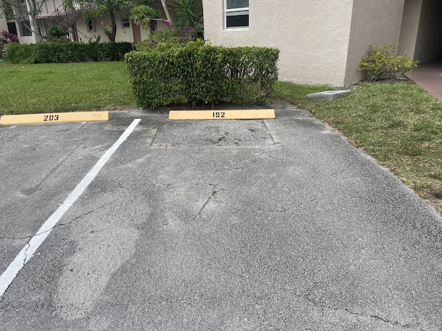 view of parking / parking lot featuring a lawn