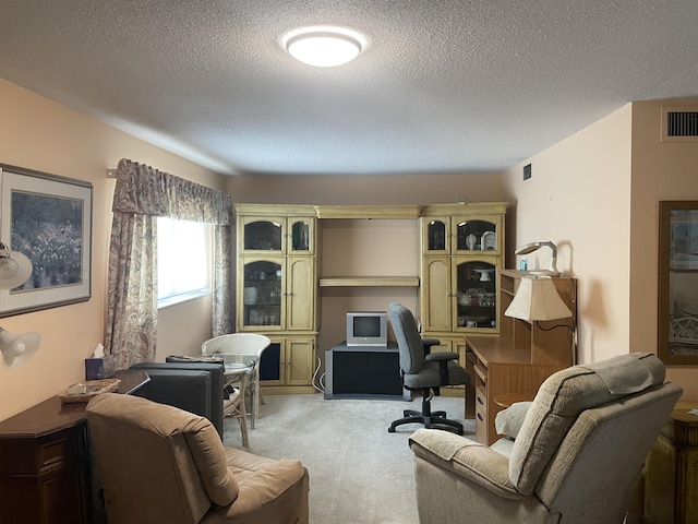 home office featuring light carpet and a textured ceiling