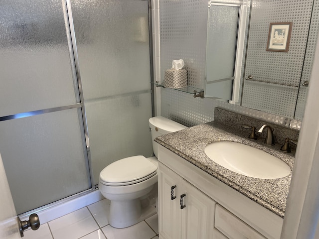 bathroom featuring toilet, vanity, tile patterned flooring, and an enclosed shower