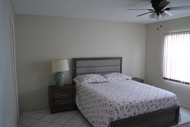 tiled bedroom featuring a textured ceiling and ceiling fan