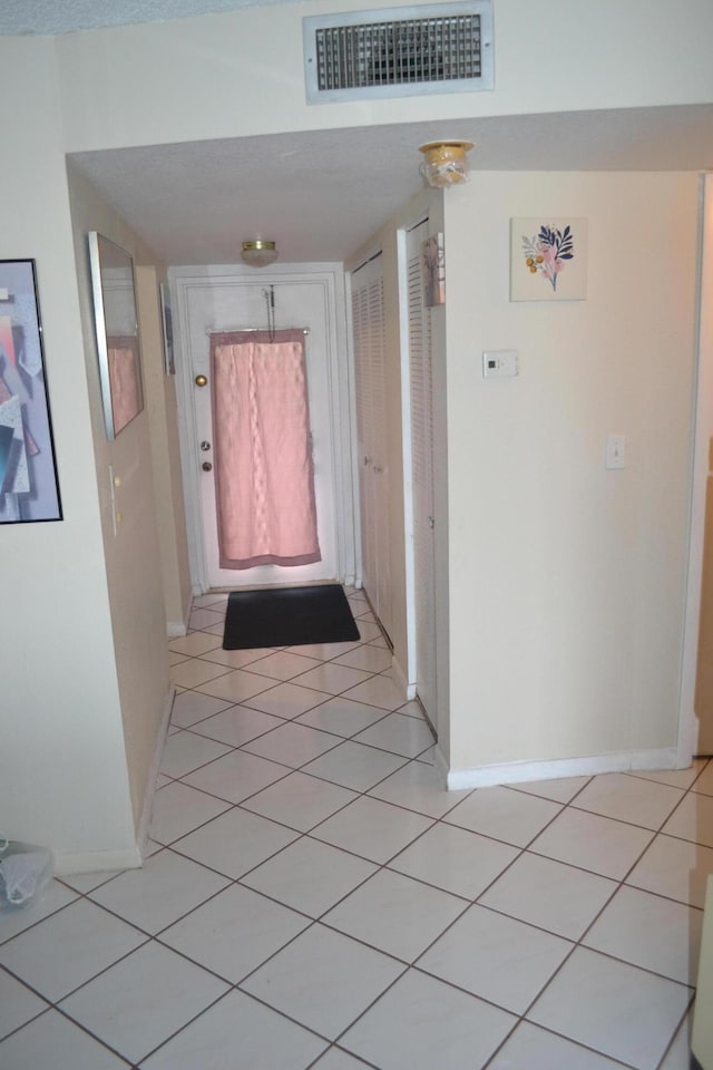 hallway featuring light tile floors