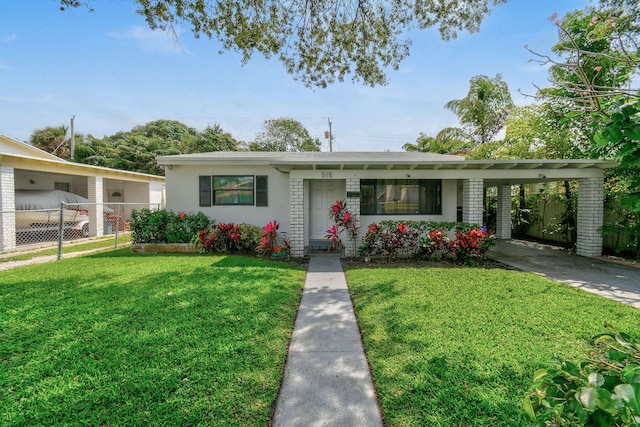 ranch-style home featuring a front lawn and a carport