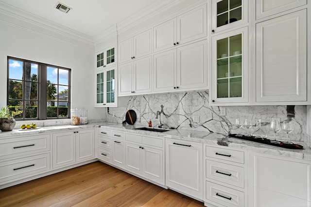 kitchen with tasteful backsplash, sink, and white cabinets