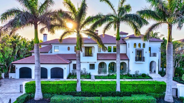 mediterranean / spanish-style home featuring a yard and a garage