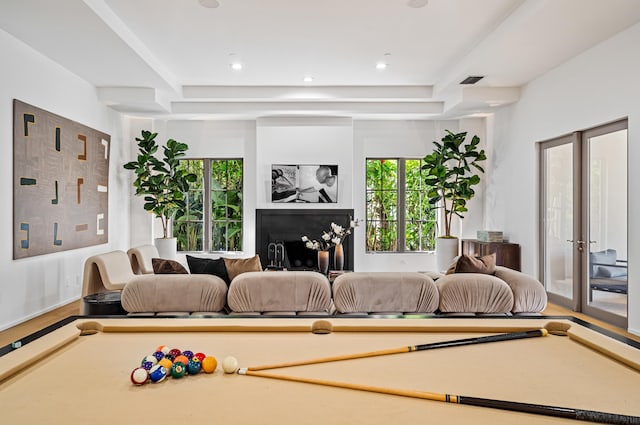 living room with a raised ceiling, french doors, hardwood / wood-style floors, and pool table