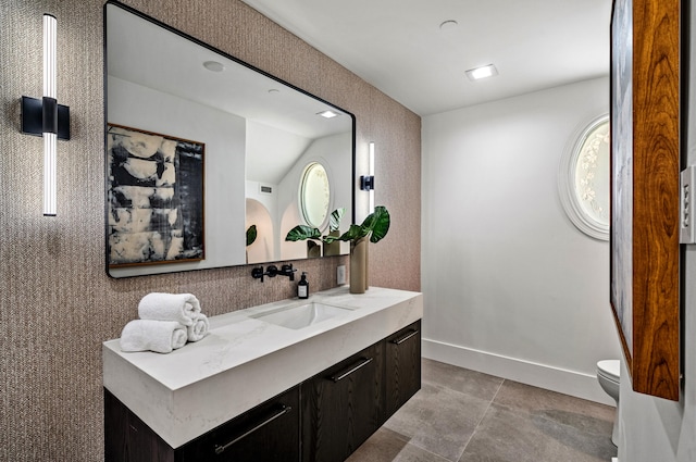 bathroom with vanity, toilet, and lofted ceiling