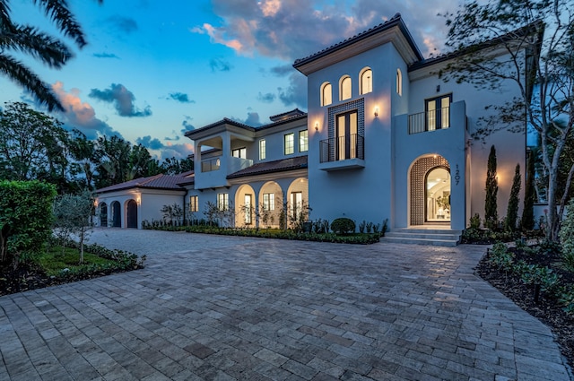 mediterranean / spanish-style home with a balcony and a garage