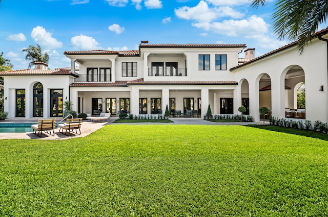 back of house featuring a balcony, a yard, and a patio