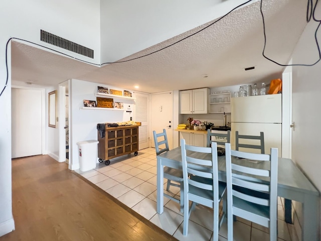 dining area with a textured ceiling and light tile flooring