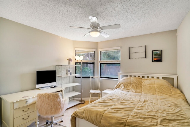 bedroom with a textured ceiling, carpet floors, and ceiling fan