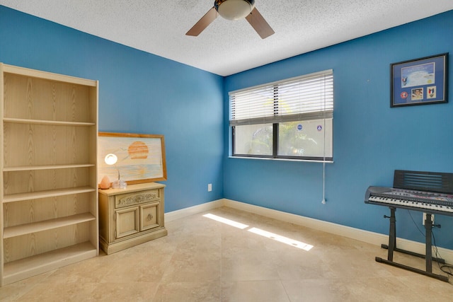 tiled office space featuring ceiling fan and a textured ceiling