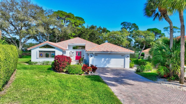 mediterranean / spanish house featuring a front lawn and a garage