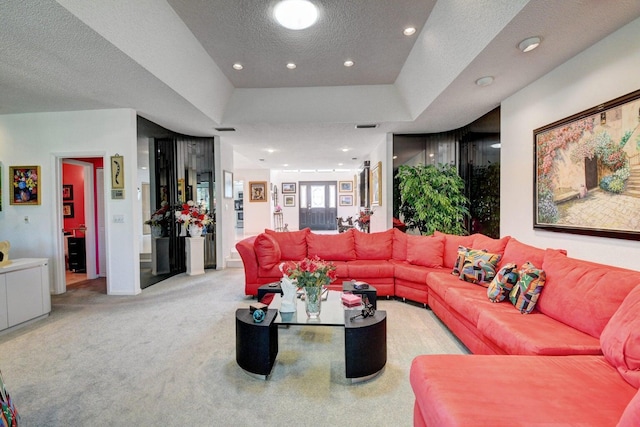 carpeted living room with a textured ceiling and a raised ceiling