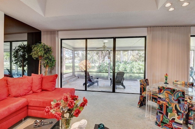 living room featuring ceiling fan, light colored carpet, and a textured ceiling