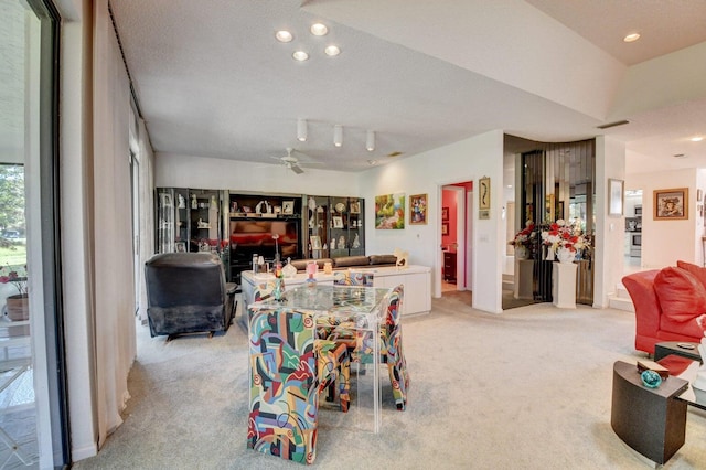 recreation room with light carpet, ceiling fan, and a textured ceiling