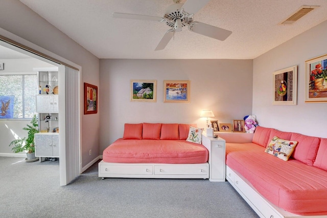 living room with carpet flooring, ceiling fan, and a textured ceiling