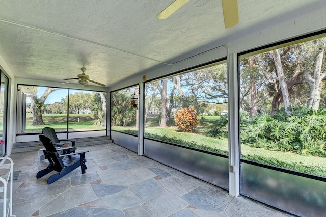 unfurnished sunroom featuring ceiling fan