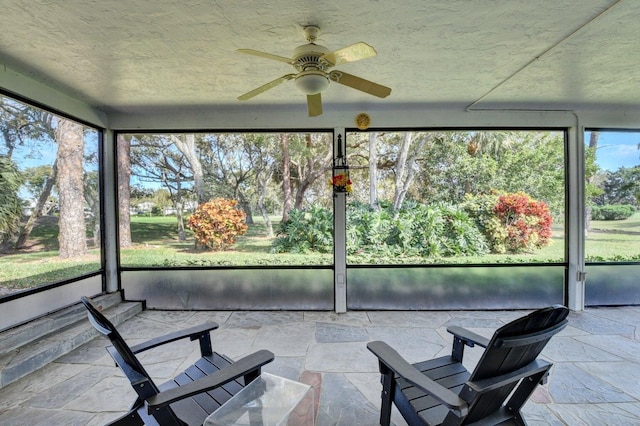 unfurnished sunroom featuring ceiling fan