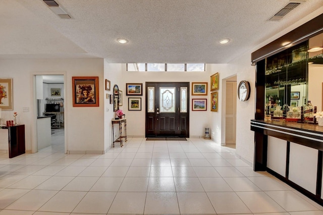 foyer with light tile patterned floors and a textured ceiling