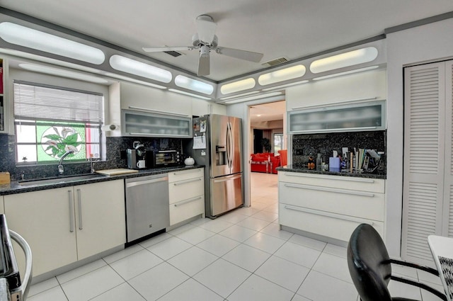 kitchen featuring decorative backsplash, sink, white cabinets, and appliances with stainless steel finishes