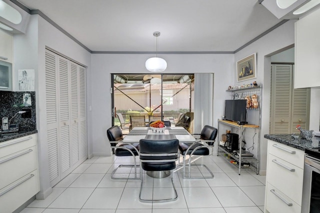 tiled dining space featuring crown molding