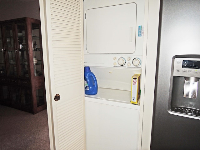 laundry area featuring stacked washer and clothes dryer and dark colored carpet