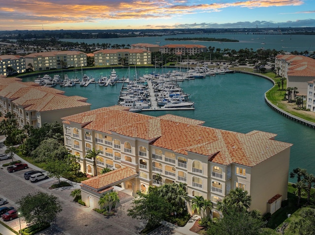 aerial view at dusk featuring a water view