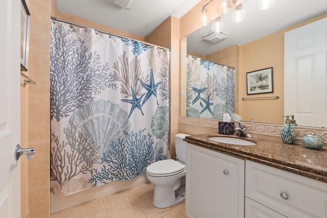 bathroom with a textured ceiling, oversized vanity, tile floors, and toilet