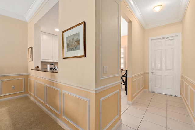 hallway with ornamental molding and light tile floors