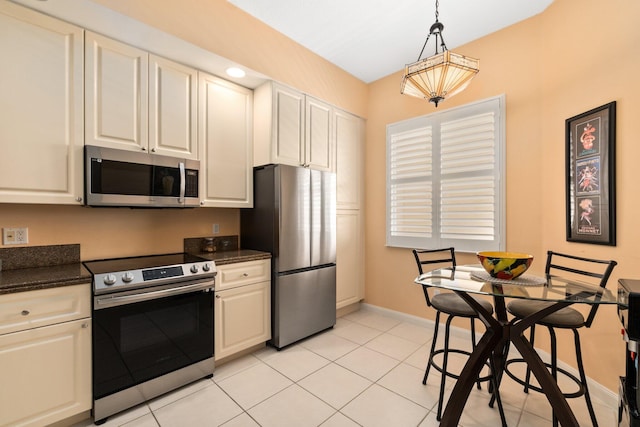 kitchen featuring appliances with stainless steel finishes, white cabinetry, light tile floors, and decorative light fixtures