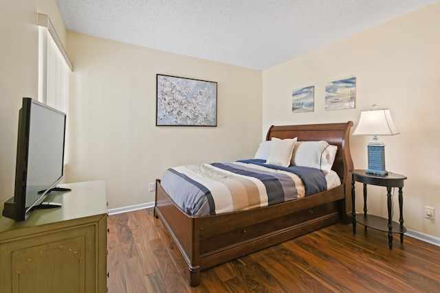 bedroom featuring dark hardwood / wood-style flooring and a textured ceiling