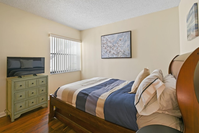 bedroom with dark hardwood / wood-style flooring and a textured ceiling