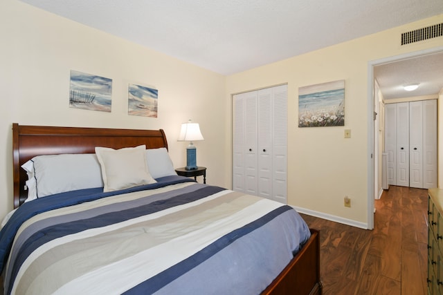 bedroom with dark hardwood / wood-style flooring and a closet