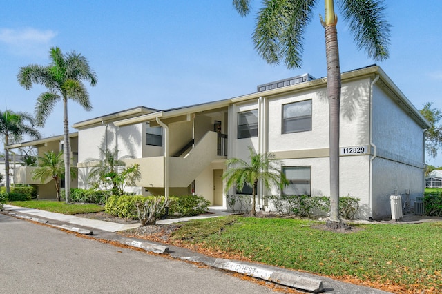 townhome / multi-family property featuring central AC and a front yard