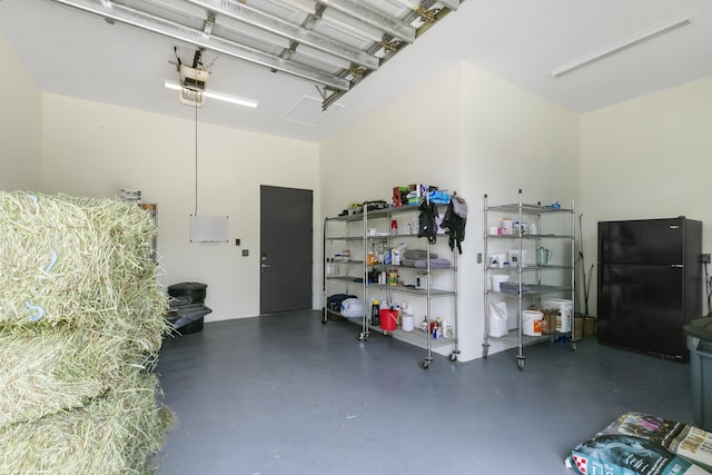 garage featuring black refrigerator and a garage door opener