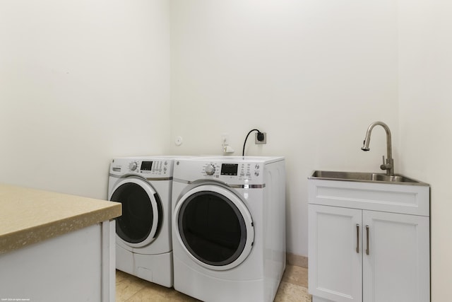 laundry room with cabinets, light tile patterned floors, washer and clothes dryer, and sink