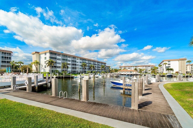 view of dock with a water view and a lawn