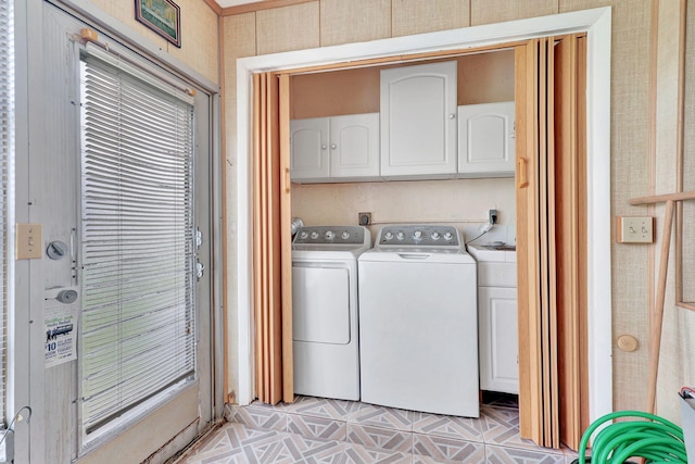 washroom featuring cabinets, washing machine and dryer, light tile floors, and electric dryer hookup