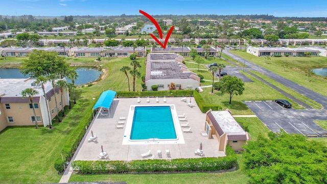 view of swimming pool featuring a lawn and a water view