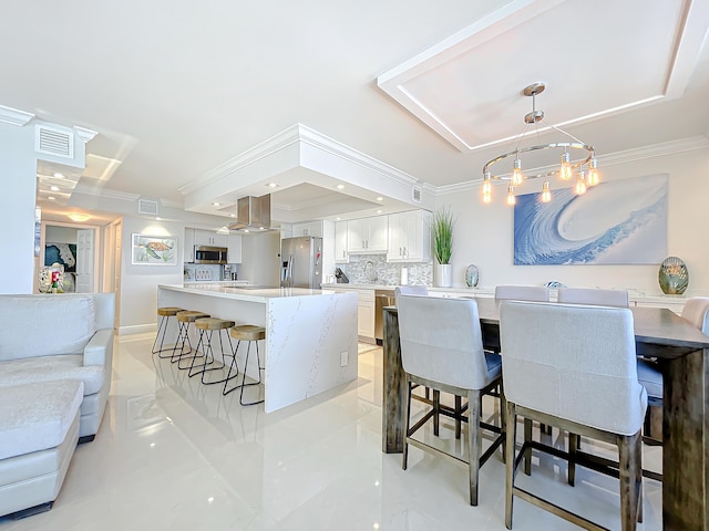 kitchen with pendant lighting, a kitchen bar, appliances with stainless steel finishes, and light tile floors