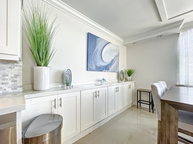 interior space with ornamental molding, light tile flooring, and backsplash