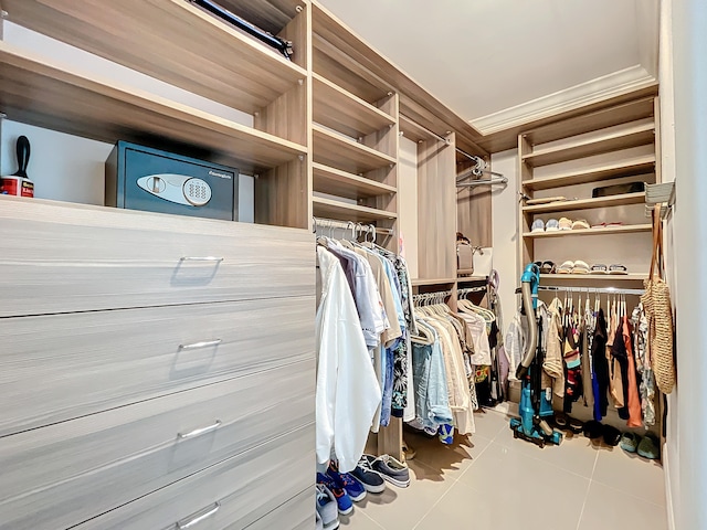 walk in closet with light tile floors