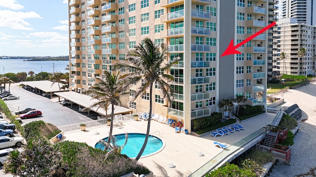 view of building exterior with a water view and a community pool