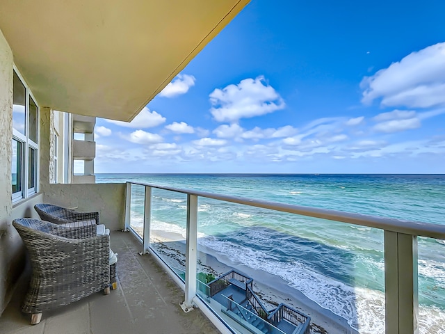 balcony with a water view and a beach view