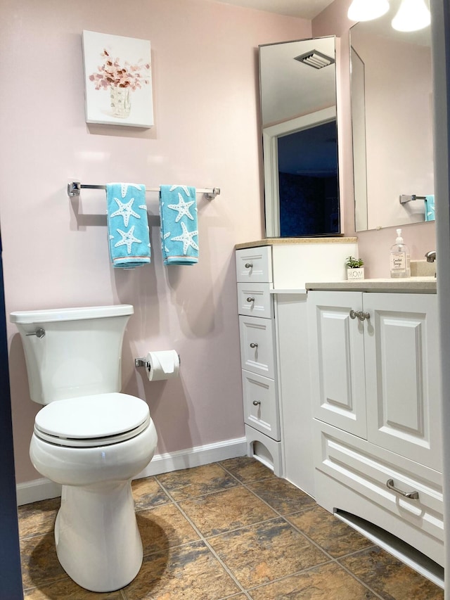 bathroom featuring tile flooring, vanity, and toilet