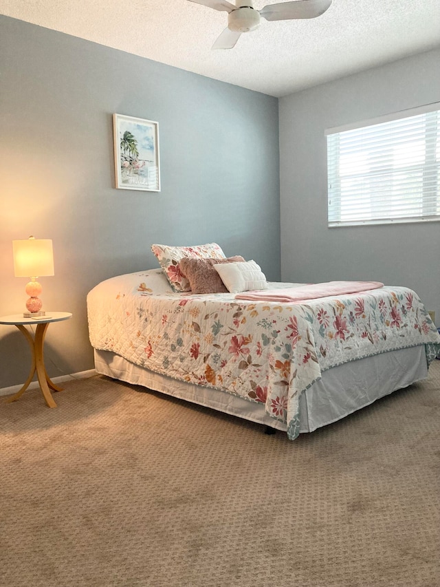 carpeted bedroom with ceiling fan and a textured ceiling